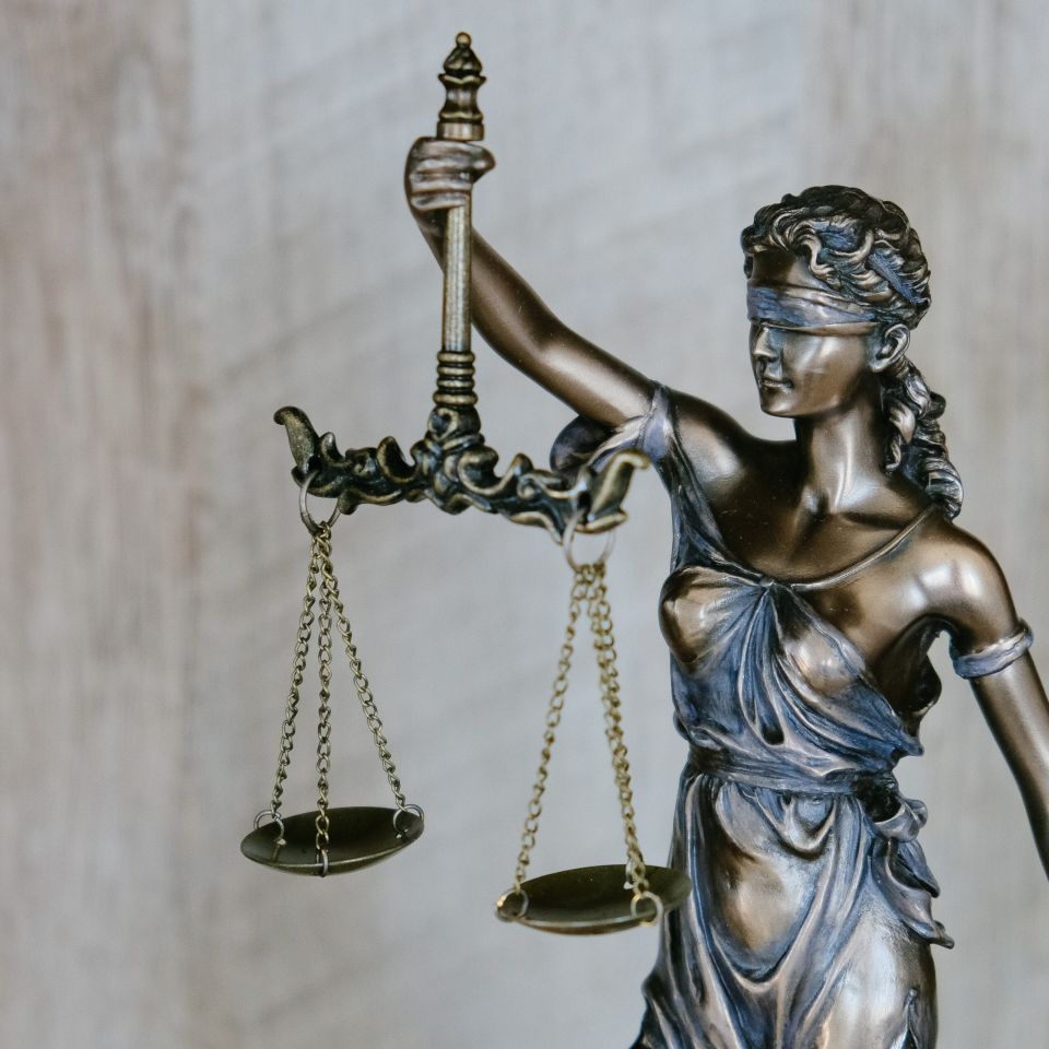 Justitia hält mit verbundnen Augen eine Waage